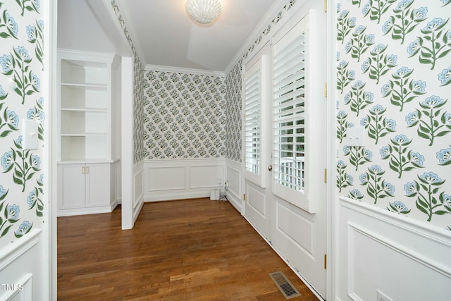 interior space featuring visible vents, dark wood-type flooring, wallpapered walls, crown molding, and wainscoting