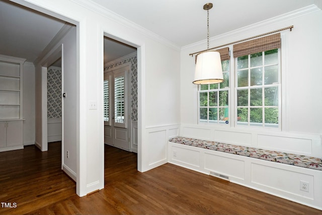 unfurnished dining area with dark wood-style floors, plenty of natural light, and ornamental molding