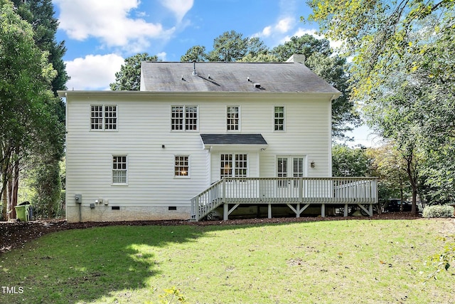 rear view of property featuring crawl space, a yard, a deck, and a chimney