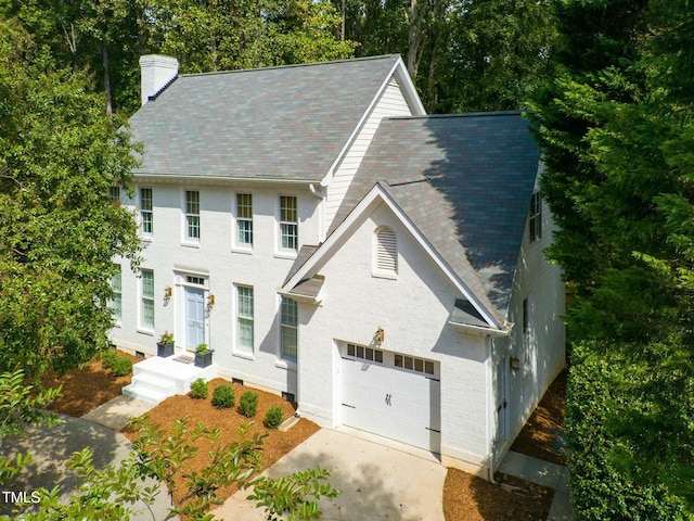 colonial home with a garage and a chimney