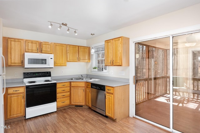 kitchen with white microwave, a sink, electric range oven, dishwasher, and light wood-type flooring