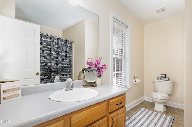 bathroom featuring visible vents, toilet, tile patterned flooring, baseboards, and vanity