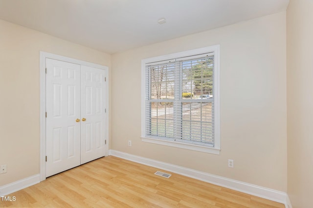 unfurnished bedroom featuring visible vents, baseboards, and multiple windows