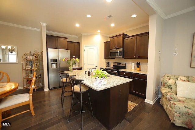 kitchen with dark wood finished floors, dark brown cabinets, appliances with stainless steel finishes, and a sink