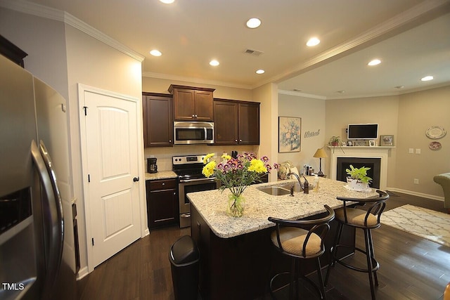 kitchen with a kitchen bar, visible vents, dark wood finished floors, stainless steel appliances, and dark brown cabinetry