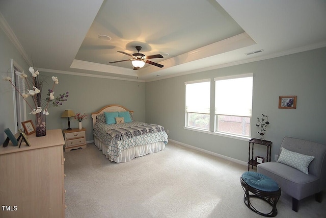 bedroom featuring a raised ceiling, light colored carpet, visible vents, and baseboards