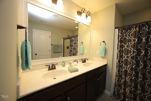 bathroom featuring curtained shower, double vanity, and a sink