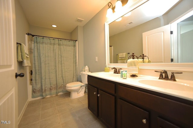 bathroom with double vanity, tile patterned flooring, toilet, and a sink