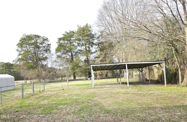 view of yard with a detached carport, a gate, and fence