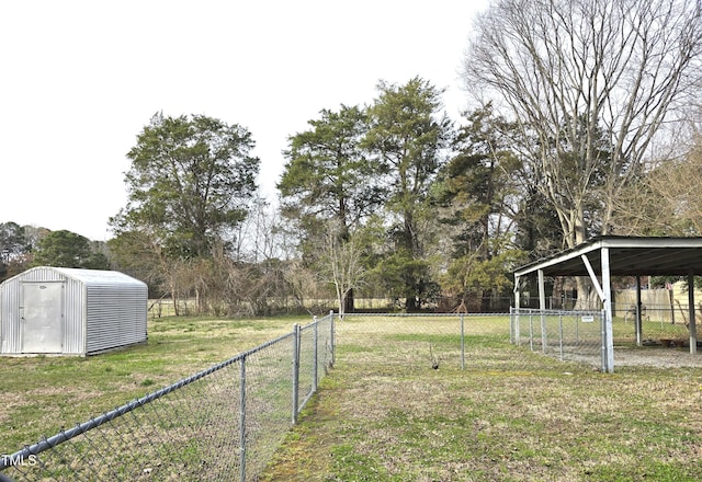 view of yard featuring a storage unit, a detached carport, an outdoor structure, and fence