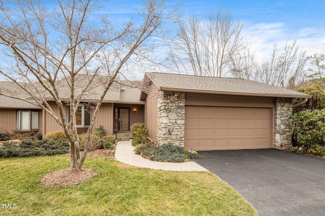 view of front of home with aphalt driveway, stone siding, an attached garage, and a front lawn