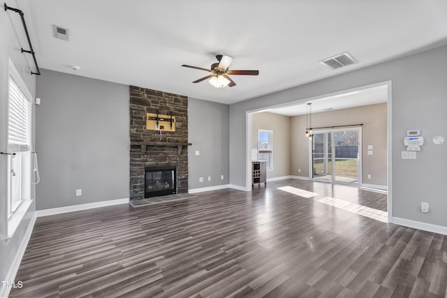 unfurnished living room with visible vents, a fireplace, dark wood-type flooring, and ceiling fan