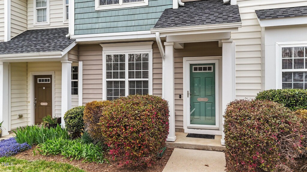 view of exterior entry with a shingled roof