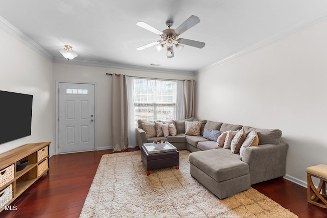 living area with crown molding, wood finished floors, baseboards, and ceiling fan