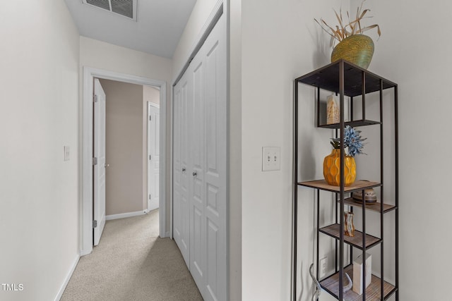 hall featuring visible vents, baseboards, and carpet