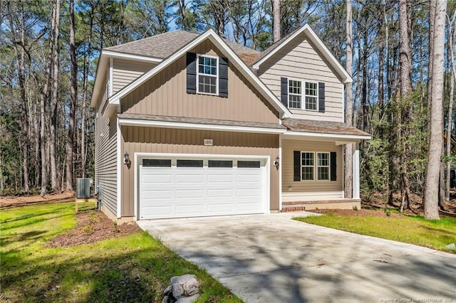 view of front of home with a front yard, central AC unit, driveway, and roof with shingles