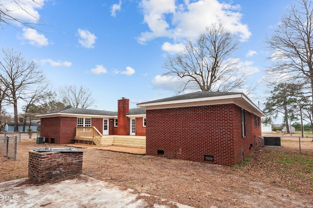 205 Woodside Dr, Goldsboro, NC 27534 - back of house featuring central AC, fence, crawl space, brick siding, and a chimney