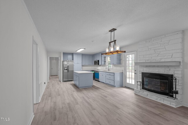 205 Woodside Dr, Goldsboro, NC 27534 - kitchen with a sink, a textured ceiling, light wood finished floors, and stainless steel appliances