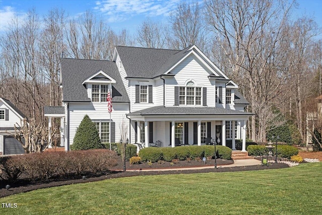 view of front of house with a front lawn, covered porch, and a shingled roof