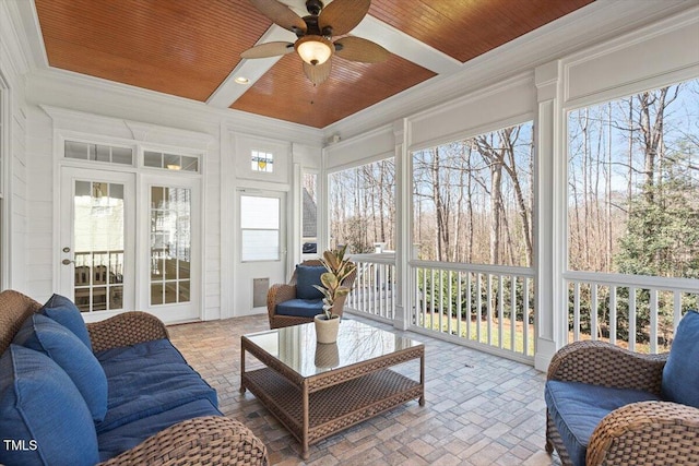 sunroom / solarium with wooden ceiling, a healthy amount of sunlight, and ceiling fan