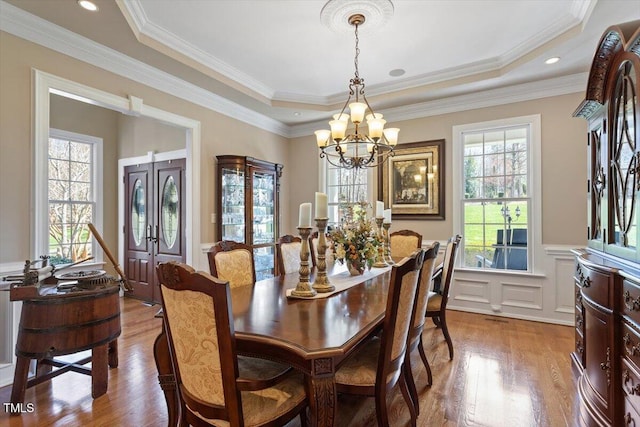 dining space with plenty of natural light, wood finished floors, and wainscoting