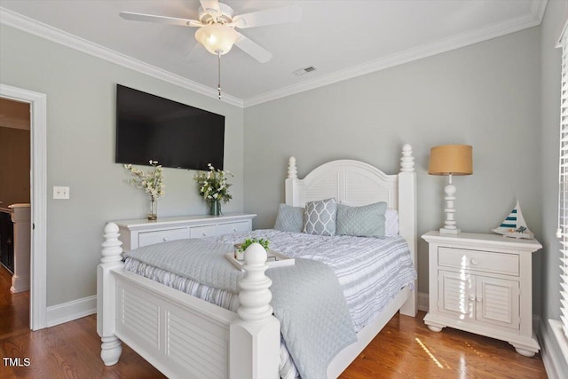 bedroom featuring visible vents, ornamental molding, and wood finished floors