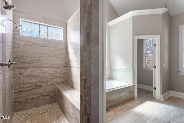 bathroom featuring baseboards, tiled shower, and a garden tub