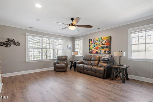 living room featuring wood finished floors, baseboards, and ornamental molding