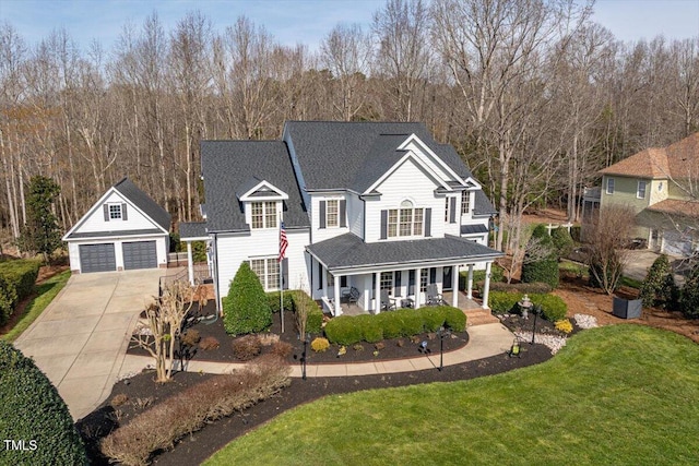 traditional-style house featuring a front lawn, a detached garage, a porch, roof with shingles, and an outdoor structure