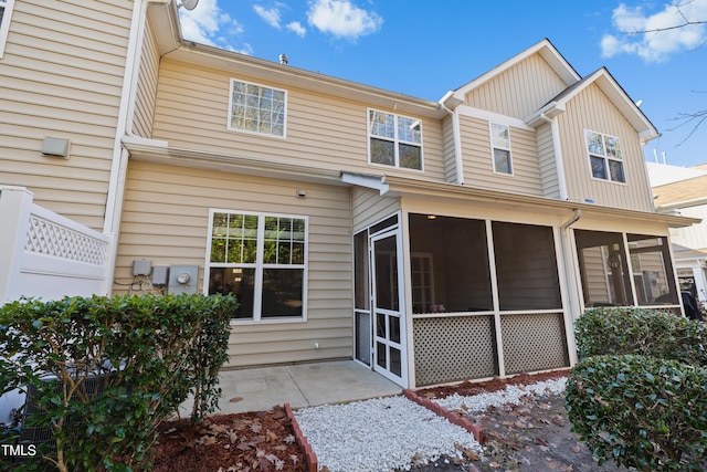 rear view of house with a patio area and a sunroom