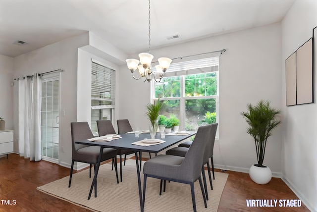 dining space with visible vents, baseboards, an inviting chandelier, and wood finished floors