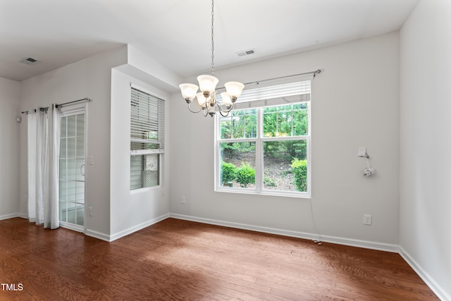 unfurnished room with visible vents, baseboards, and wood finished floors