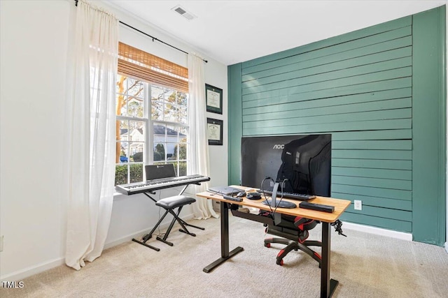 carpeted office with wooden walls, baseboards, and visible vents