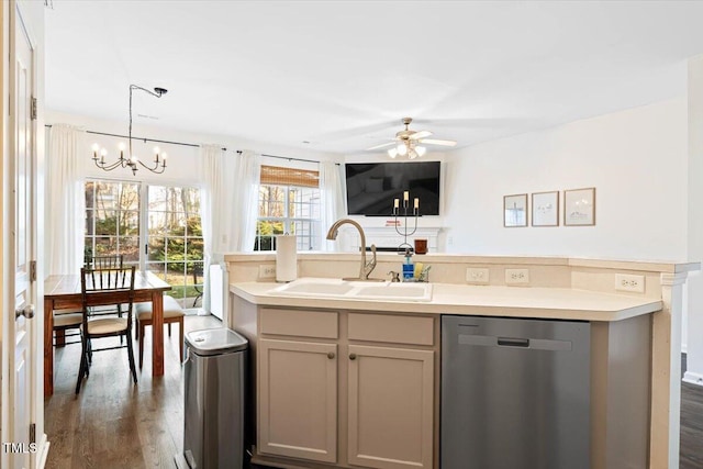 kitchen featuring dark wood-type flooring, a kitchen island with sink, ceiling fan with notable chandelier, a sink, and dishwasher