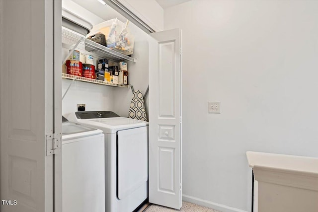 washroom with baseboards, independent washer and dryer, and laundry area