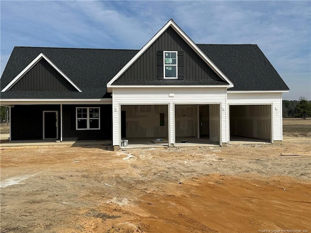 view of front facade featuring a garage, roof with shingles, and board and batten siding