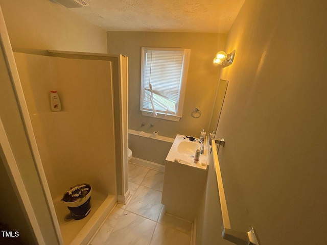 full bathroom featuring toilet, marble finish floor, a textured ceiling, walk in shower, and vanity