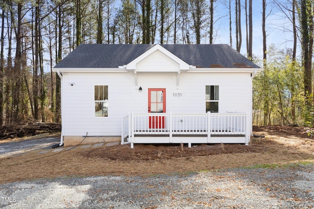 view of front of property with a wooden deck and a shingled roof