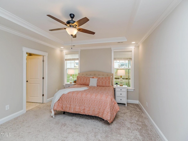 carpeted bedroom featuring baseboards, a raised ceiling, ceiling fan, and crown molding