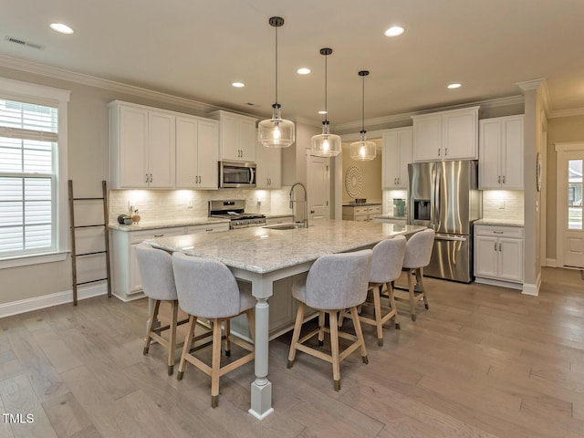 kitchen featuring stainless steel appliances, visible vents, white cabinets, and crown molding