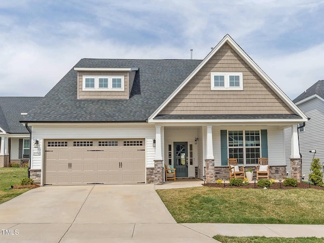 craftsman inspired home with driveway, a porch, an attached garage, a front lawn, and stone siding