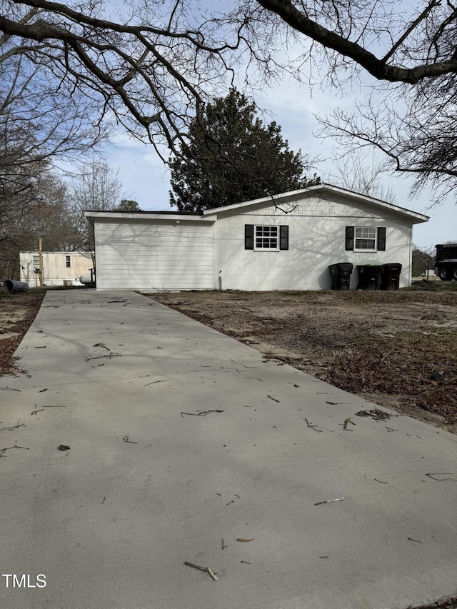 view of property exterior with concrete driveway