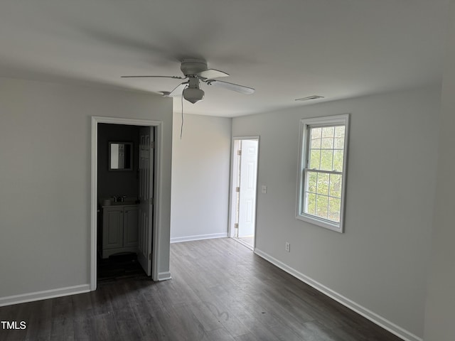 unfurnished room featuring visible vents, baseboards, dark wood-style flooring, a sink, and ceiling fan