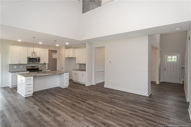 5815 James Allen Ln, Stedman, NC 28391 - kitchen with stainless steel appliances, white cabinets, an island with sink, recessed lighting, and a high ceiling