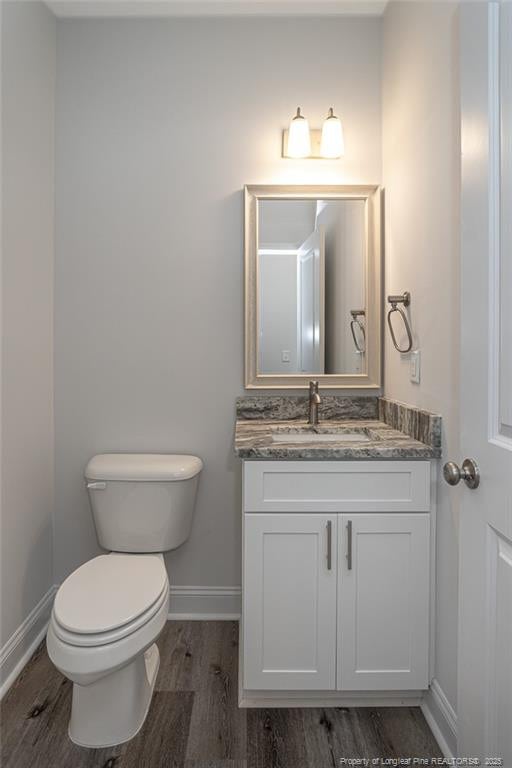 5815 James Allen Ln, Stedman, NC 28391 - bathroom with baseboards, wood finished floors, vanity, and toilet