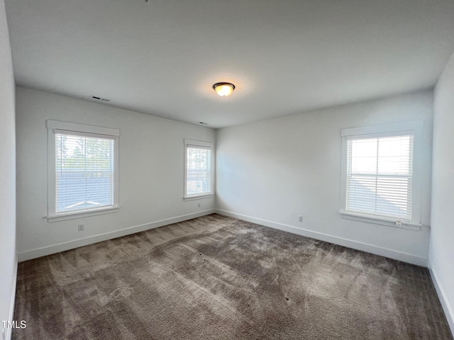 carpeted empty room with baseboards