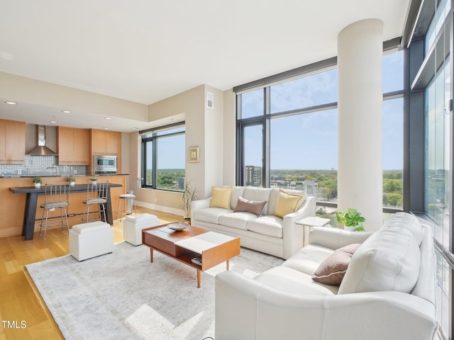 living room featuring recessed lighting, baseboards, visible vents, and light wood finished floors
