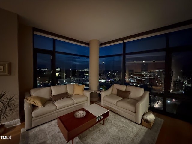 living room with a view of city lights and wood finished floors