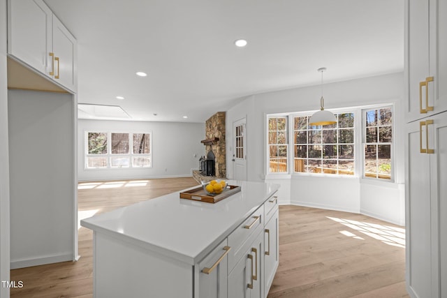 kitchen with light wood finished floors, recessed lighting, a healthy amount of sunlight, and a fireplace