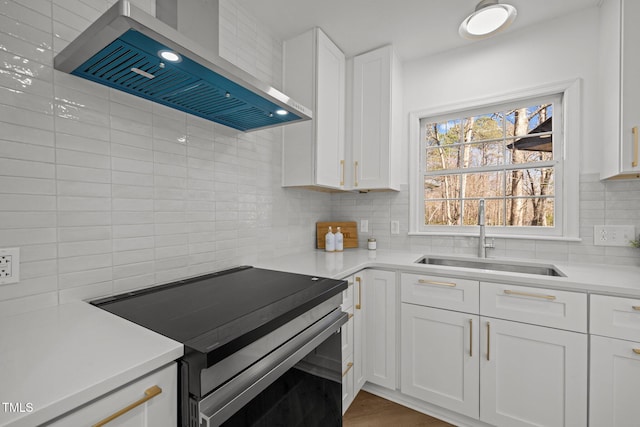 kitchen with a sink, white cabinets, electric stove, wall chimney exhaust hood, and tasteful backsplash